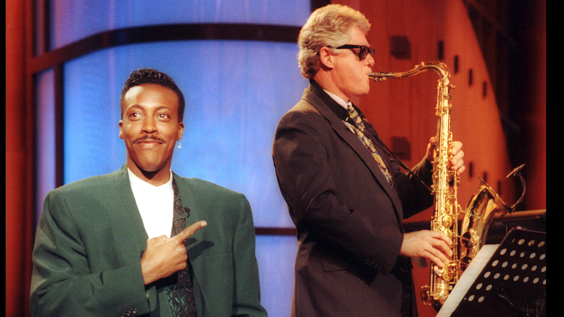 Gov. Bill Clinton, sitting with the band, turns out an impressive version of "Heatrbreak Hotel" as Arsenio Hall gestures approvingly in the musical opening of "The Arsenio Hall Show" taping at Paramount Studios in Hollywood, June 3, 1992. (AP Photo/Reed Saxon)
